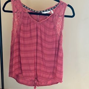 This is a medium tank by LUQ. It’s a dusty pink color with a tie at the waist.